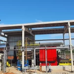 Instalação externa de secagem de lenha com trabalhadores.