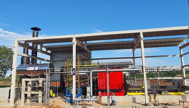 Instalação externa de secagem de lenha com trabalhadores.