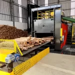 Forno industrial secando toras de eucalipto em esteira.